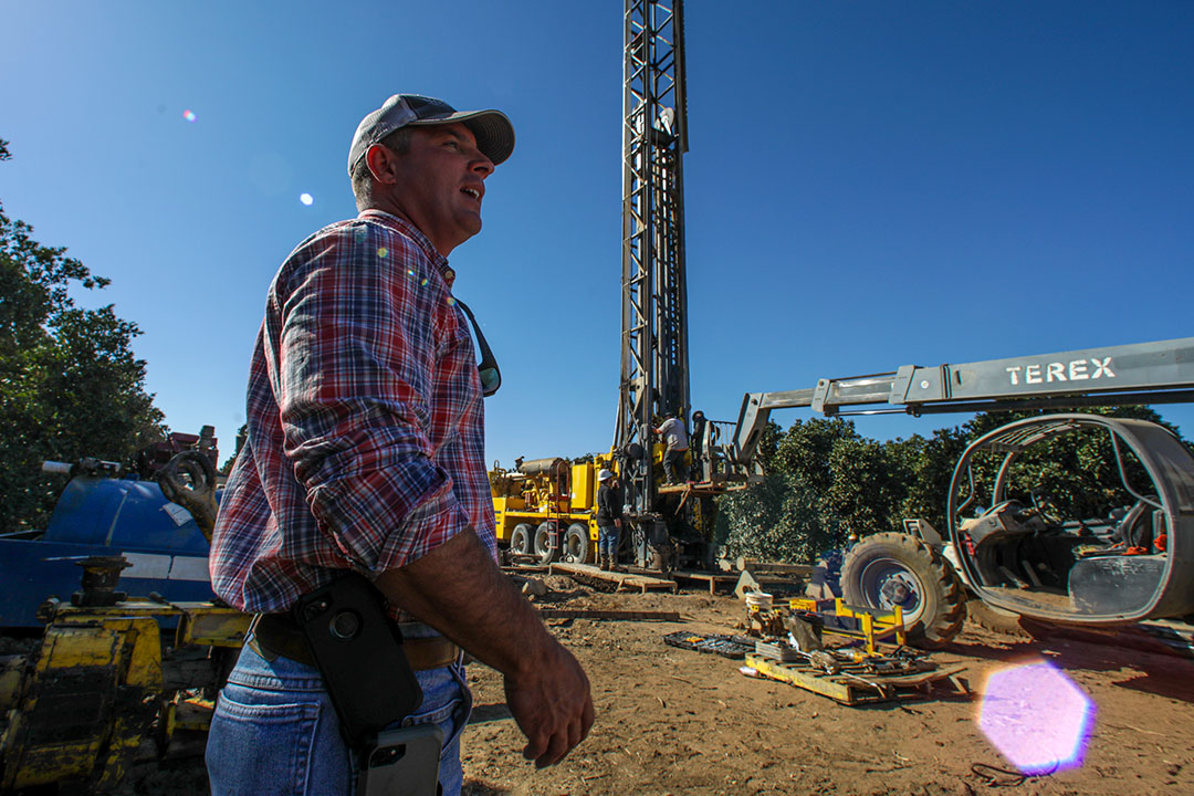 Matthew Davis walks in front of a well drilling site.
